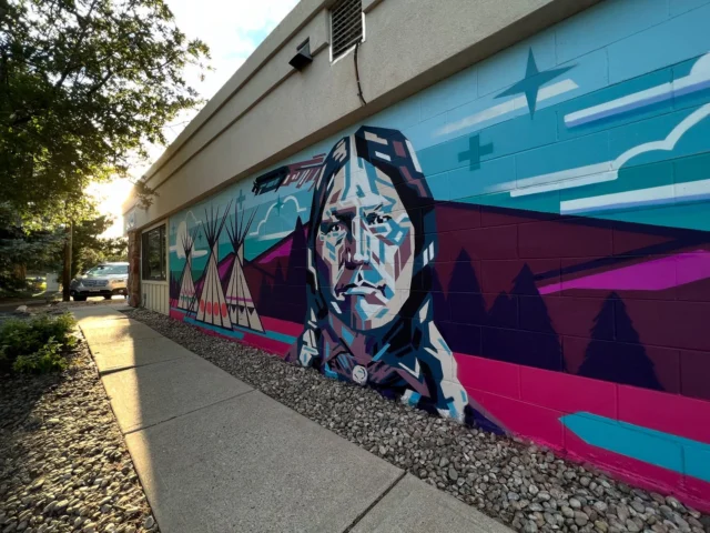 Chief Niwot 🪶🦬 🏹 Our town is the namesake of this remarkable individual. Known for his diplomatic and peaceful approach in colonist relations during the Pike’s Peak Gold Rush. 

This mural, located on the south side of the Jerry Sinor building, was created by artist JayCee Beyale, who, after researching Arapaho photo collections, compiled characteristics to conceptualize a portrait of Chief Niwot. (Interesting fact: there are actually no confirmed photos captured of Chief Niwot!)

Niwot, meaning “Left Hand,” was a prominent leader of the Southern Arapaho people during the mid-19th century. Fluent in English, thanks to his brother-in-law John Poisal, Niwot served as a diplomat and interpreter, striving to maintain peace between the Arapaho and the increasing number of settlers on tribal lands. 

He and his people often wintered in the Boulder Valley, an area they held sacred. In 1858, upon encountering gold prospectors near Boulder Creek, Niwot is said to have issued a prophetic warning, now known as “Niwot’s Curse”: “People seeing the beauty of this valley will want to stay, and their staying will be the undoing of the beauty”. **Edit: While “Niwot’s Curse” is commonly referred to in local storytelling, there is currently no substantiated account of this occurring.***

Today, Chief Niwot’s legacy endures in various place names throughout Boulder County, including the town of Niwot, Left Hand Creek, and Niwot Mountain. His commitment to peace and his poignant warning about the impact of settlement continue to resonate in the region’s history.

#niwot #niwotcolorado  #coloradonativeamericans #arapahocolorado #cheyennecolorado #nativehistorycolorado #bouldernativehistory #nativearapaho #nativecheyenne #chiefniwot #chieflefthand #niwotco #jayceebeyale #coloradohistory #boulderhistory #niwothistory